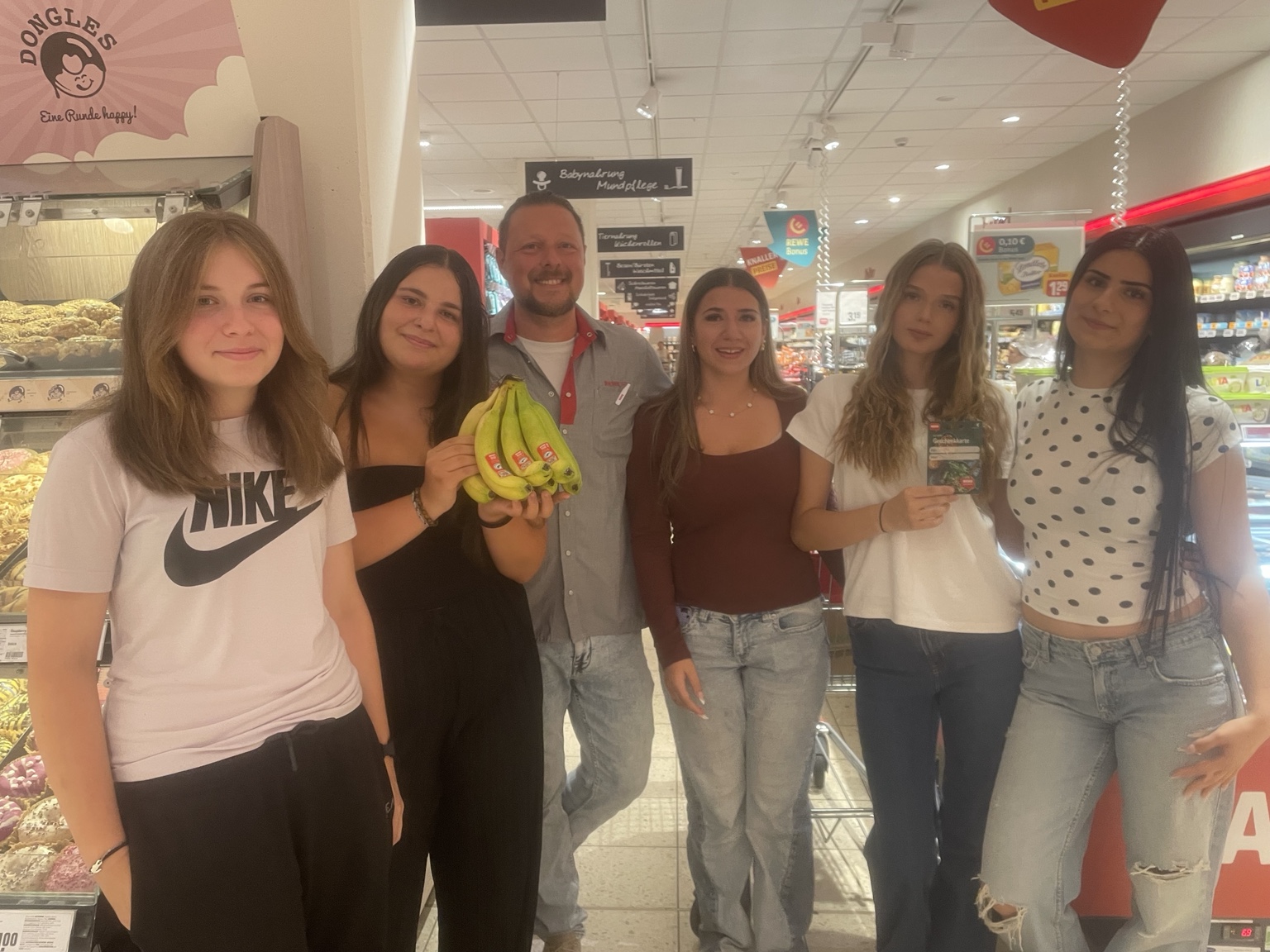 Mitglieder des Sozialteams bei der Übergabe fair gehandelter Bananen im REWE Markt Bad Ems