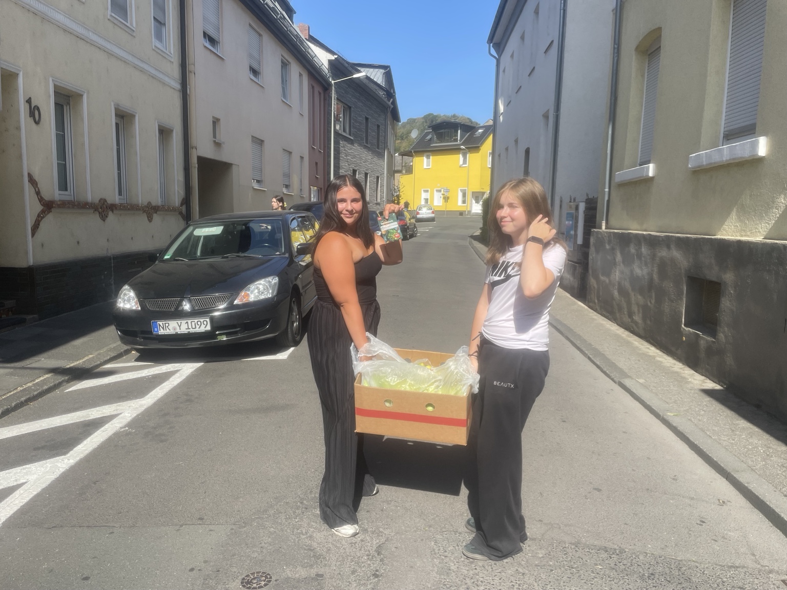 Zwei Schülerinnen bringen die gespendeten fair gehandelten Bananen zur Schule