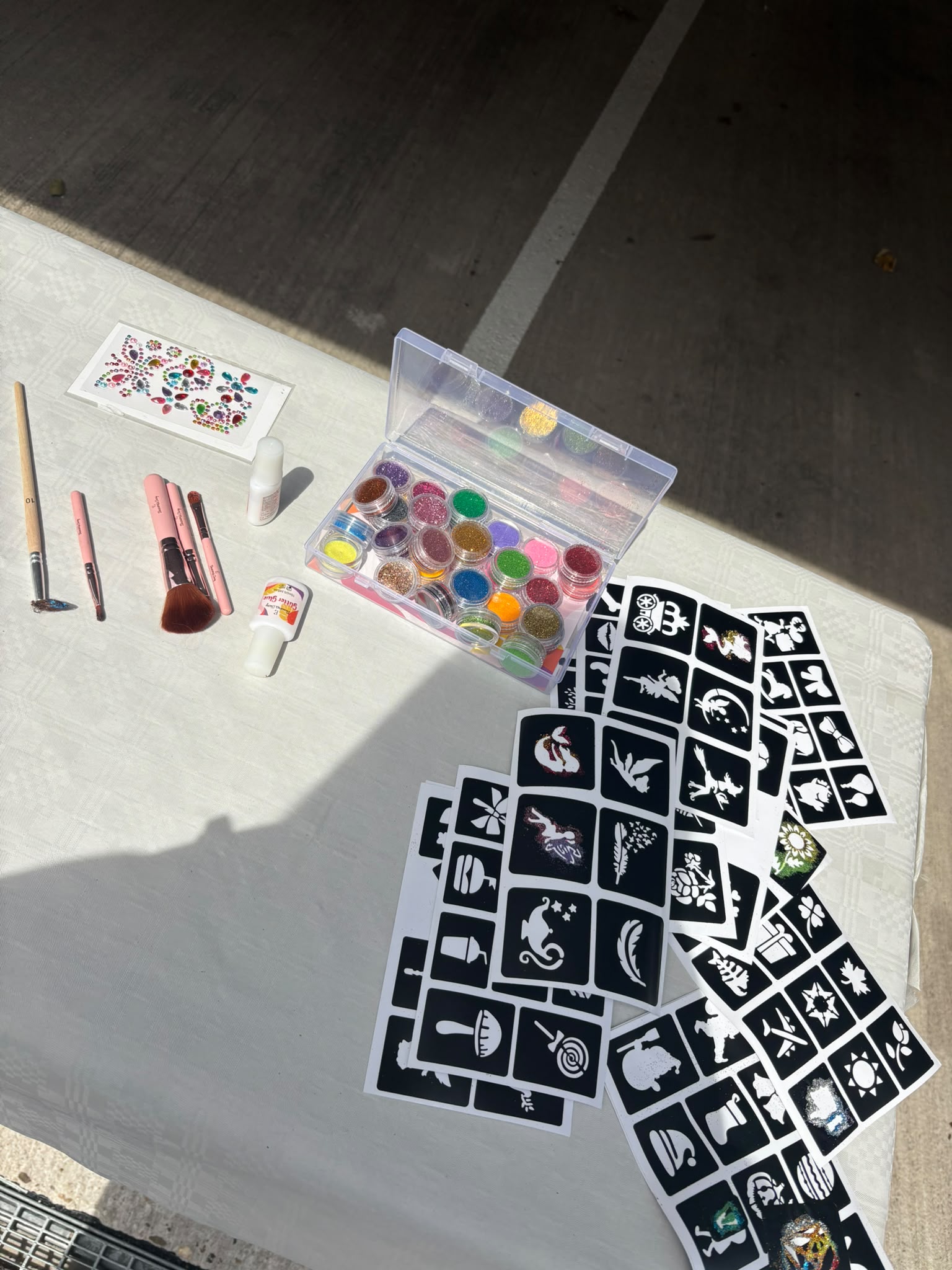 Bunte Glitzerfarben, Pinsel und Schablonen auf dem Kreativtisch